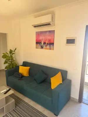 a green couch in a living room with yellow pillows at 304 aqua blue bay in Hurghada