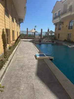 a swimming pool with a bench next to a building at 304 aqua blue bay in Hurghada