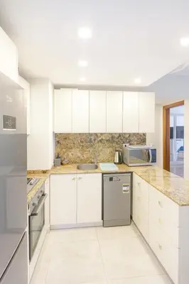 a white kitchen with white cabinets and appliances at The View Hurghada Poolfront Sea View Apartment in Hurghada