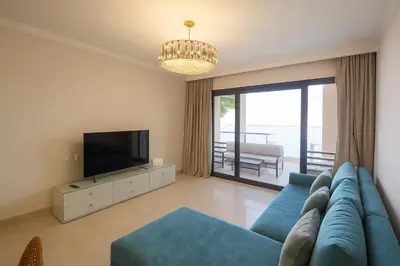 a living room with a blue couch and a television at The View Hurghada Poolfront Sea View Apartment in Hurghada