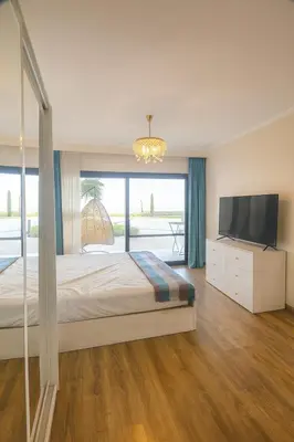 a bedroom with a large bed and a television at The View Hurghada Poolfront Sea View Apartment in Hurghada