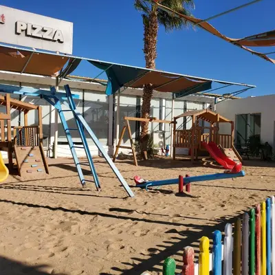 a playground in the sand next to a building at Poolside Chalet Ground Floor Aqua Park - BY MAMO Property in Hurghada