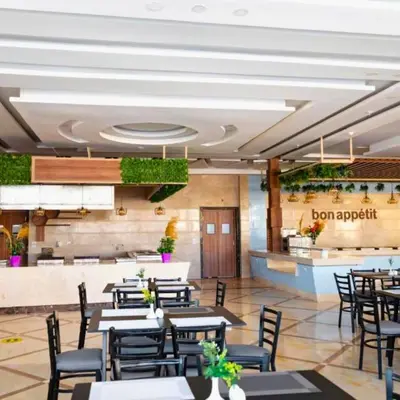 a dining room with tables and chairs in a restaurant at Poolside Chalet Ground Floor Aqua Park - BY MAMO Property in Hurghada
