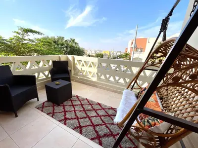 a balcony with two chairs and a white fence at Casa Seherezade in Hurghada
