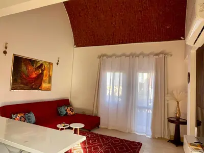 a living room with a red couch and a window at Casa Seherezade in Hurghada