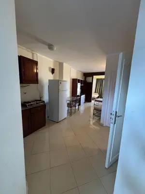 a kitchen with a refrigerator and a table and chairs at Bahia Hurghada - 2 Bedrooms Serviced Apartment - City view in Hurghada