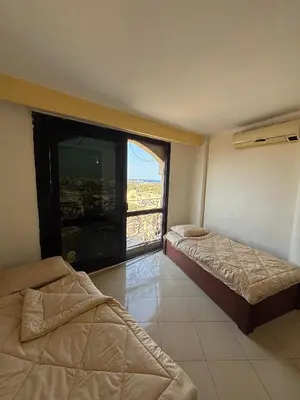 a room with two beds and a large window at Bahia Hurghada - 2 Bedrooms Serviced Apartment - City view in Hurghada