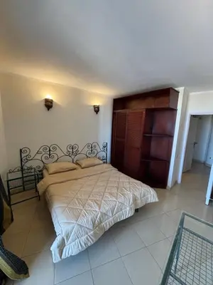 a bedroom with a large bed with a wooden headboard at Bahia Hurghada - 2 Bedrooms Serviced Apartment - City view in Hurghada
