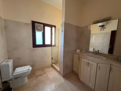 a bathroom with a sink and a toilet and a window at Waterfront Sabina I 4Bdr Retreat - Heated Pool in Hurghada
