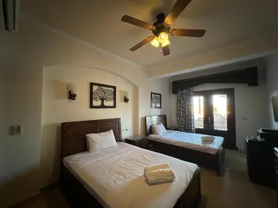a bedroom with two beds and a ceiling fan at Waterfront Sabina I 4Bdr Retreat - Heated Pool in Hurghada