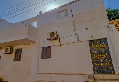 a white building with a window and a door at Luxor Grand House in ‘Ezbet Abu Ḥabashi