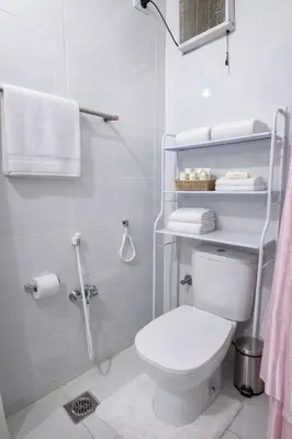 a bathroom with a toilet and a shower with towels at Luxor Grand House in ‘Ezbet Abu Ḥabashi