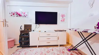 a room with a desk and a tv on a wall at Luxor Grand House in ‘Ezbet Abu Ḥabashi