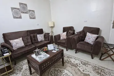 a living room with two couches and a coffee table at Luxor Grand House in ‘Ezbet Abu Ḥabashi