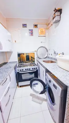 a kitchen with a stove and a sink at Luxor Grand House in ‘Ezbet Abu Ḥabashi