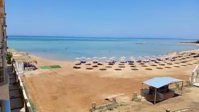 a beach with chairs and umbrellas and the ocean at Casablanca beach in Hurghada