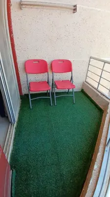 two red chairs sitting on top of a green floor at Casablanca beach in Hurghada