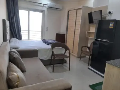 a bedroom with a bed and a couch and a tv at Casablanca beach in Hurghada