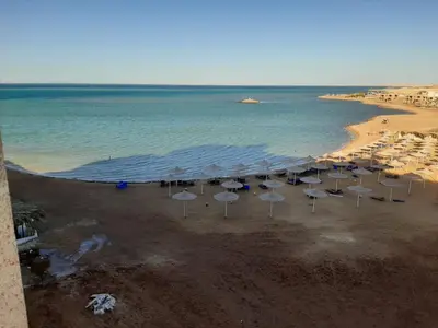 a group of umbrellas on a beach with the ocean at Casablanca beach in Hurghada