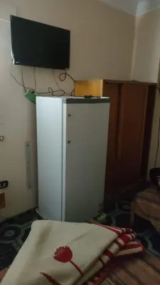 a room with a white refrigerator with a television on top at New mostafa hotel in Luxor