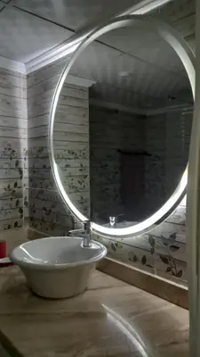 a bathroom with a sink and a round mirror at Palma chalet 169 in Hurghada