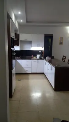 a large kitchen with white cabinets and a tile floor at Palma chalet 169 in Hurghada