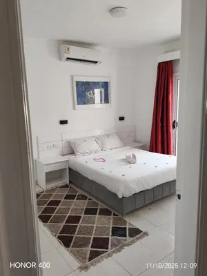 a bedroom with a bed and a red curtain at Elixir Two Bed Rooms in Hurghada