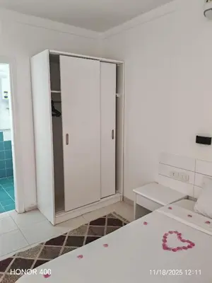 a white room with a bed and a closet at Elixir Two Bed Rooms in Hurghada