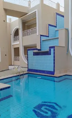 a swimming pool with a blue tile staircase in a building at Pool Dream Hurghada in Hurghada