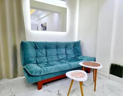 a blue couch in a living room with two tables at Pool Dream Hurghada in Hurghada