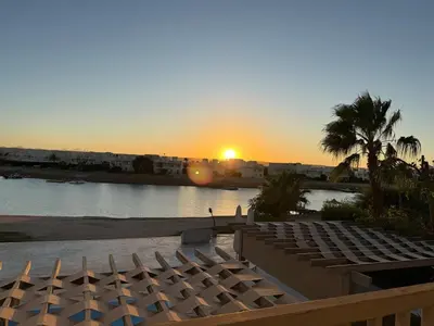a sunset over a body of water with a beach at The Nest Namaste - El Gouna in Hurghada