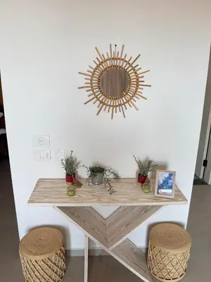 a table with two stools and a mirror on a wall at Boho Beach Chalet in El Gouna with pool access in Hurghada