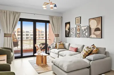 a living room with a couch and a balcony at Posh Gouna Poolside in Hurghada