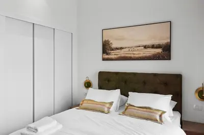 a bedroom with a bed with white sheets and gold pillows at Posh Gouna Poolside in Hurghada
