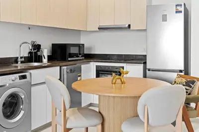 a kitchen with a wooden table with chairs and a sink at Posh Gouna Poolside in Hurghada