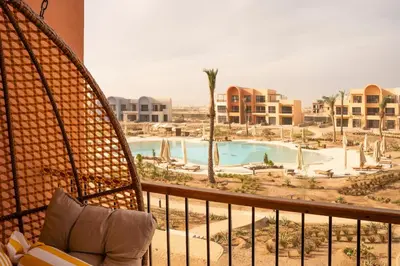 a balcony with a view of a pool and buildings at Posh Gouna Poolside in Hurghada