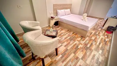 a bedroom with a bed and a chair and a table at Nile Hotel in Aswan