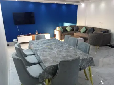 a dining room with a table and chairs and a couch at fanadir resort in Hurghada