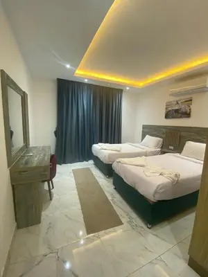 a hotel room with two beds and a mirror at Fanadir Chalet 3BR in Hurghada