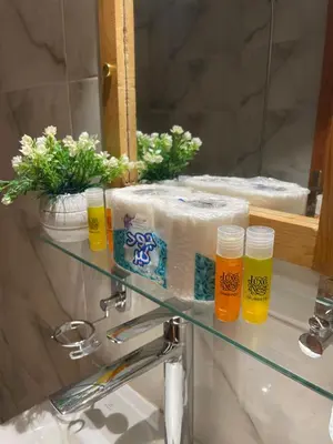 a bathroom sink with towels on a shelf in front of a mirror at Luxe Nest Luxor Serviced Apartments 201 in Luxor