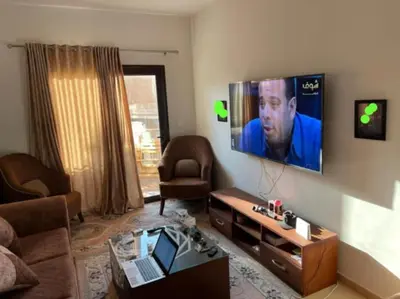 a living room with a couch and a tv on the wall at Turtle beach resort in Hurghada