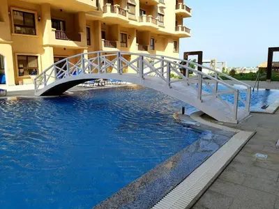a white bridge over a pool in front of a building at Turtle beach resort in Hurghada