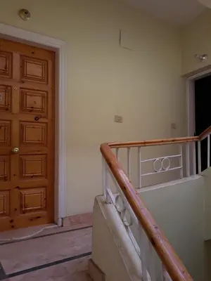 an empty room with a staircase and a wooden door at Obelisk house in Luxor