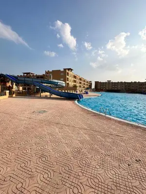 a walkway next to the water with a slide at Sahl Hasheesh in Hurghada