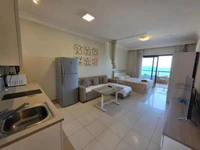 a kitchen and living room with a couch and a refrigerator at New studio in the view in Hurghada