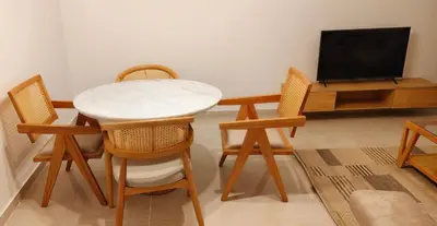 a living room with a table and chairs and a tv at Moon Hills Palace in Hurghada