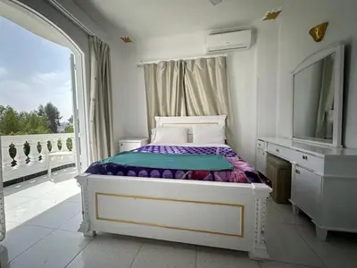a bedroom with a bed with a mirror and a window at Villa Shanhouri Nile View in Luxor