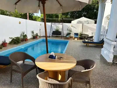 a patio with a table and chairs and a pool at Villa Shanhouri Nile View in Luxor