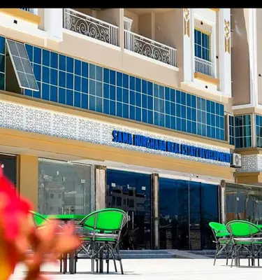 a group of chairs and tables in front of a building at Quiet, cozy resort apartment in Hurghada