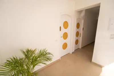 a hallway with white walls and a potted plant at Home of ISIS in Luxor